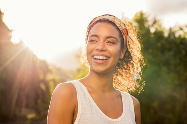 Joyful woman smiling outdoors with sunlight