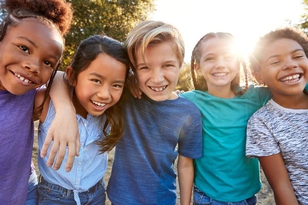 Diverse group of joyful children embracing outdoors