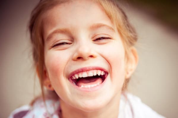 Joyful young girl laughing outdoors